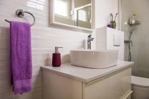 W łazience znajduje się umywalka i fioletowy ręcznik. w obiekcie Apartment Mediteran w mieście Brodarica
