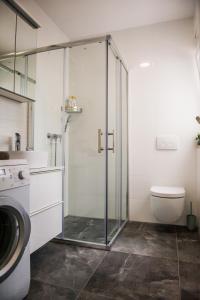 W łazience znajduje się toaleta i przeszklona kabina prysznicowa. w obiekcie Apartment Mediteran w mieście Brodarica