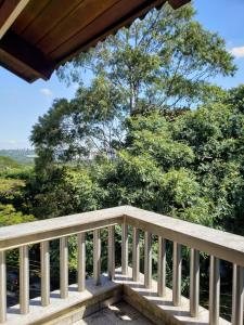 a wooden balcony with trees in the background at Pousada Monte Sião in Sao Paulo