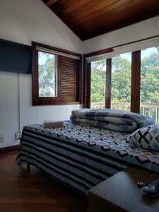 a bedroom with two beds in a room with windows at Pousada Monte Sião in Sao Paulo