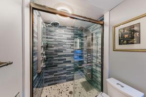 a bathroom with a shower with a glass door at Captivating Cottage in Provincetown +8 photos