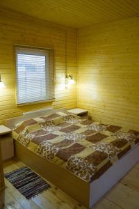 1 dormitorio con 1 cama grande en una pared de madera en Ramanov Plyos Guest House, en Vladimir