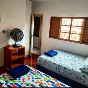 een slaapkamer met 2 bedden en een raam bij POUSADA ROSA BRANCA in Uberlândia