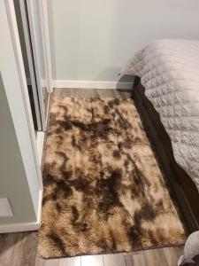 - un tapis sur un étage à côté d'un lit dans l'établissement Winnipeg Peace Home, à Winnipeg