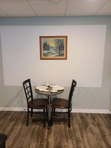 uma mesa com duas cadeiras e um quadro na parede em Winnipeg Peace Home em Winnipeg