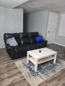 a living room with a black couch and a white coffee table at Winnipeg Peace Home in Winnipeg