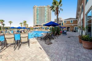 una piscina con sillas y sombrillas y un edificio en Portofino #2009 en Pensacola Beach