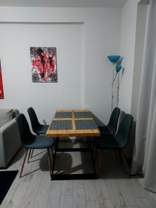 una mesa en una habitación con sillas y una pintura en Apartment en Ioánina