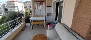 einen Balkon mit einem Sofa und einem Tisch auf dem Balkon in der Unterkunft Dreamhause 2+1 in Kusadası