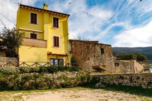 Un edificio amarillo con pájaros volando a su alrededor. en Il Tramonto Holidays, en Trevi