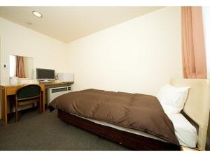 Un dormitorio con una cama y un escritorio con una computadora. en Hotel Marui - Vacation STAY 14596v, en Shibata