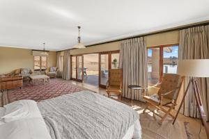 a bedroom with a bed and a living room at Drakensberg Luxury Accommodation - Misty Ridge in Himeville