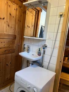 a bathroom with a sink and a washing machine at Susitupa 5 in Salla