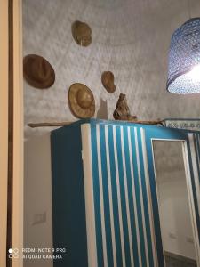 a room with a mirror and hats on the ceiling at Appartamento Luelen in Alghero
