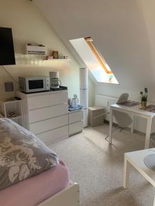 a room with a bed and a desk with a microwave at Apartment am Goethe Park in Jena