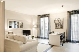 a living room with a white couch and a table at Up Suites BCN in Barcelona