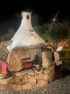 an outdoor oven with a stone wall at Cuccuru Relax - A IUN Q9882 in Orosei