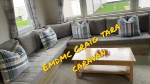 a living room with a couch with a coffee table at EMDMC Craig Tara Caravan in Ayr