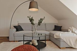 a living room with a couch and a table with a vase at 'Traveller lodge' großzügiges Apartment - 3 BR, 10min to Hbf, full kitchen, homeoffice, Netflix, Wifi in Düsseldorf