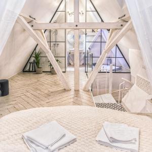 Pokój z łóżkiem z białymi ręcznikami w obiekcie Magiczne gniazdko na samym Rynku we Wrocławiu
