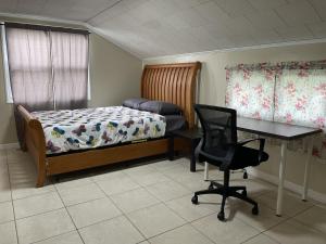 Terrace Guest House في تامبا: غرفة نوم بسرير ومكتب وكرسي