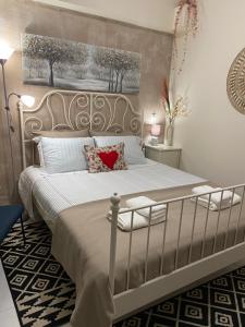 a bedroom with a white bed with a red heart pillow at Zoi's central home in Volos