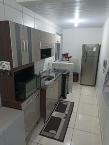 a kitchen with a sink and a refrigerator at Condomínio Residencial Mar Azul in Imbituba