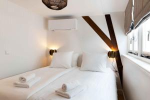 ein Schlafzimmer mit einem weißen Bett und Handtüchern darauf in der Unterkunft Finest Apartments in Haarlem