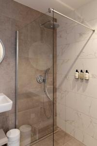 a shower with a glass door in a bathroom at Finest Apartments in Haarlem