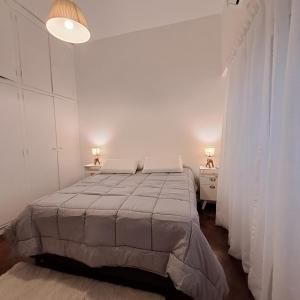 um quarto branco com uma cama e duas mesas de cabeceira em Down Town Telmo em Buenos Aires