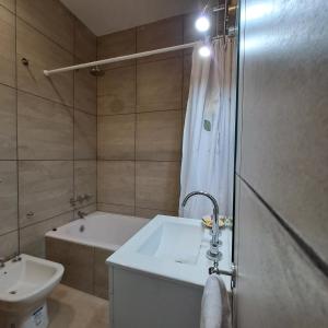 a bathroom with a tub and a sink and a shower at Down Town Telmo in Buenos Aires