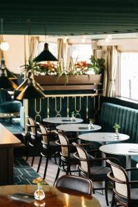 a dining room with tables and chairs and plants at Botel Maastricht in Maastricht