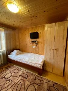 um quarto com uma cama num quarto de madeira em Made in Yaremche em Yaremche