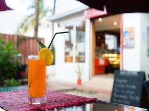 a glass of orange juice sitting on a table at La Tonnelle Guest House in Trou aux Biches
