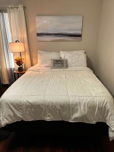 a large white bed in a bedroom with a lamp at Eagle Stay in Eagle Pass