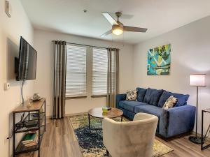 sala de estar con sofá azul y ventilador de techo en Convenient And Close To All, en Kissimmee