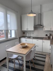 古岡佐拉的住宿－Buonarroti 37，厨房配有木桌和白色橱柜。