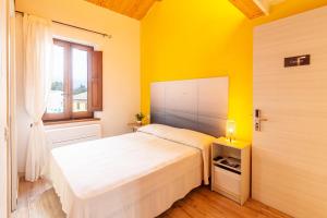 a bedroom with a white bed and a yellow wall at Sirolo Sea rooms in Sirolo