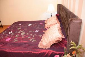 a bed with a red comforter with flowers on it at Kenzy guest house in Cairo