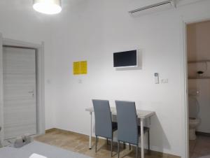 a table and chairs in a room with a toilet at PORRINO Guest House - Affittacamere in Alghero