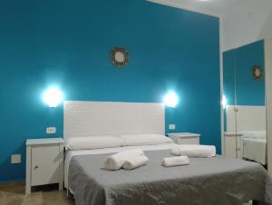 a blue bedroom with a bed with towels on it at PORRINO Guest House - Affittacamere in Alghero