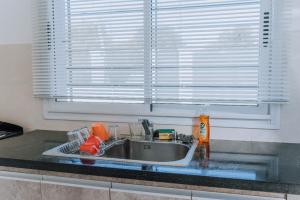 eine Küchentheke mit einem Waschbecken und einem Fenster in der Unterkunft La Tranquila in Pergamino