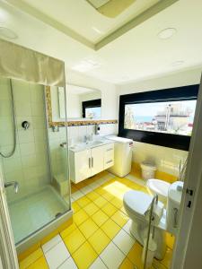 La salle de bains est pourvue de toilettes, d'une douche et d'un lavabo. dans l'établissement Suite Prestige Salerno, à Salerne