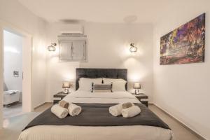 een slaapkamer met een groot bed en 2 handdoeken bij SN Santorini Apartments in Kamari