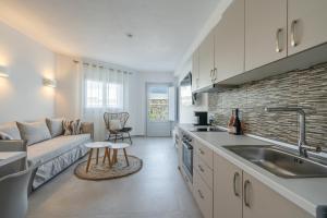 een keuken en een woonkamer met een bank en een wastafel bij SN Santorini Apartments in Kamari
