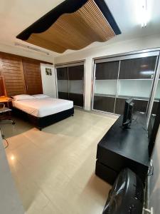 Dormitorio con cama, escritorio y TV en Ololo Caracas, en Caracas