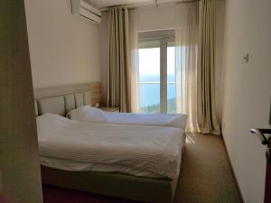 een hotelkamer met twee bedden en een raam bij Skyline View Apt & Pool Retreat in Budva +37 foto's