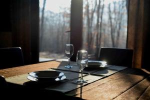 a wooden table with two wine glasses on it at Boutique Hotel Lyulyak in Starozagorski Bani