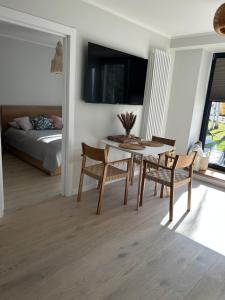 uma sala de estar com uma mesa e cadeiras e uma cama em Albatross Getaway by the sea, SPA and forest with a Terrace em Ķesterciems