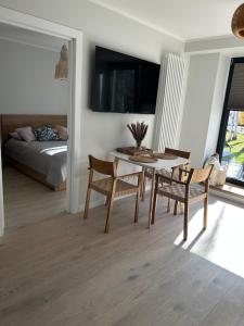 a living room with a table and chairs and a bed at Albatross Getaway by the sea, SPA and forest with a Terrace in Ķesterciems